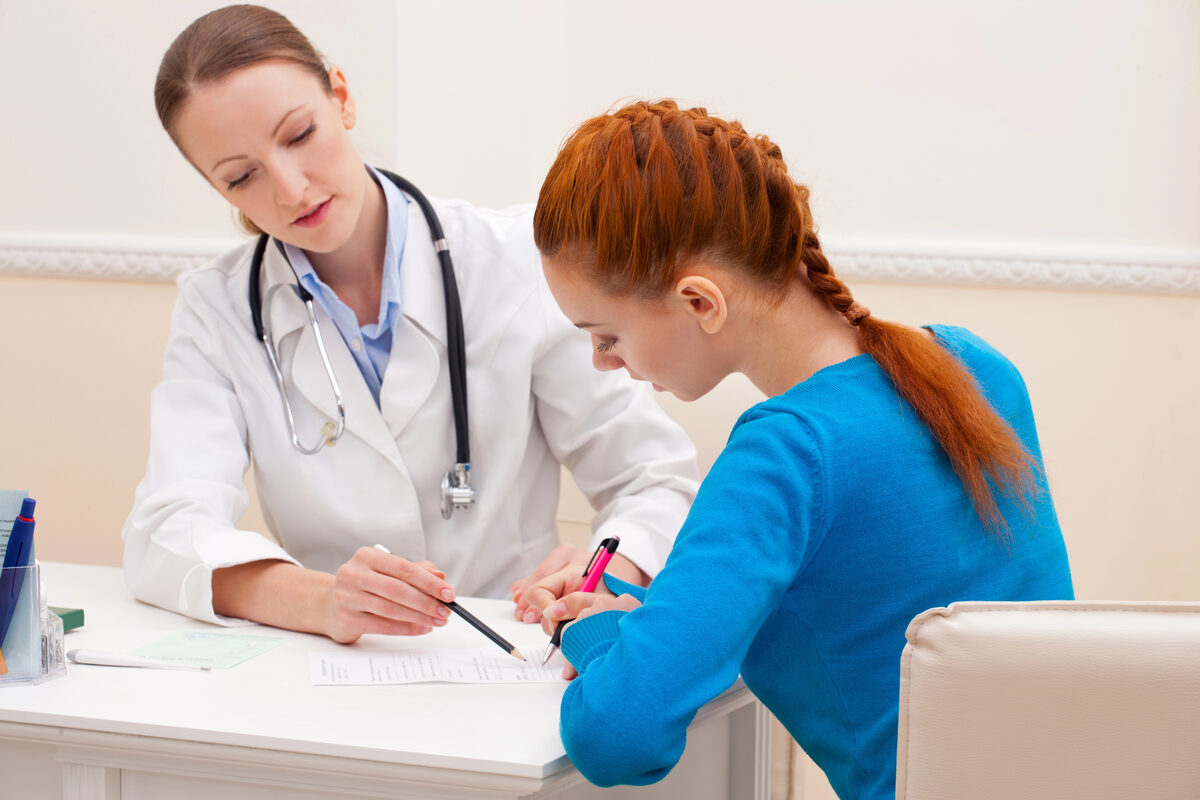 Pacientă semnând un formular la biroul medicului